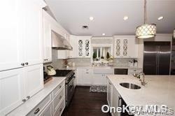 1051 Oceanfront, Unit 7 Long Beach, NY 11561 - Photo 7 of 15 a kitchen with a sink dishwasher a stove a dining table and chairs