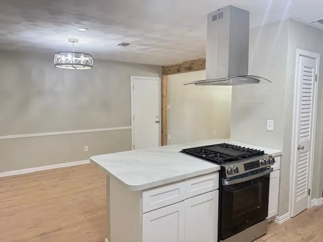 a kitchen with stainless steel appliances a stove a refrigerator and white cabinets