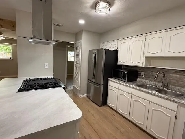 a kitchen with a sink a refrigerator and cabinets