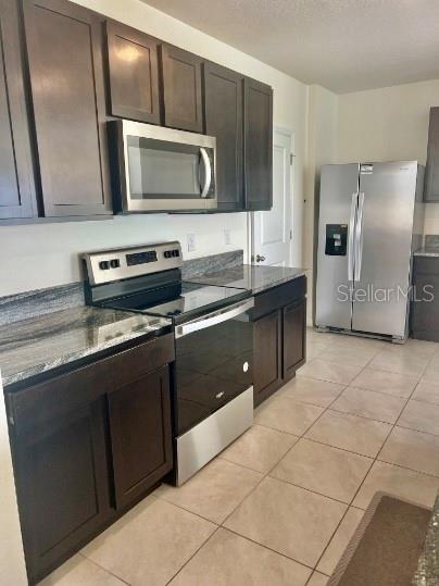 31284 Penny Surf Loop Wesley Chapel, FL 33545 - Photo 5 of 15 a kitchen with stainless steel appliances a sink a stove a microwave and a refrigerator