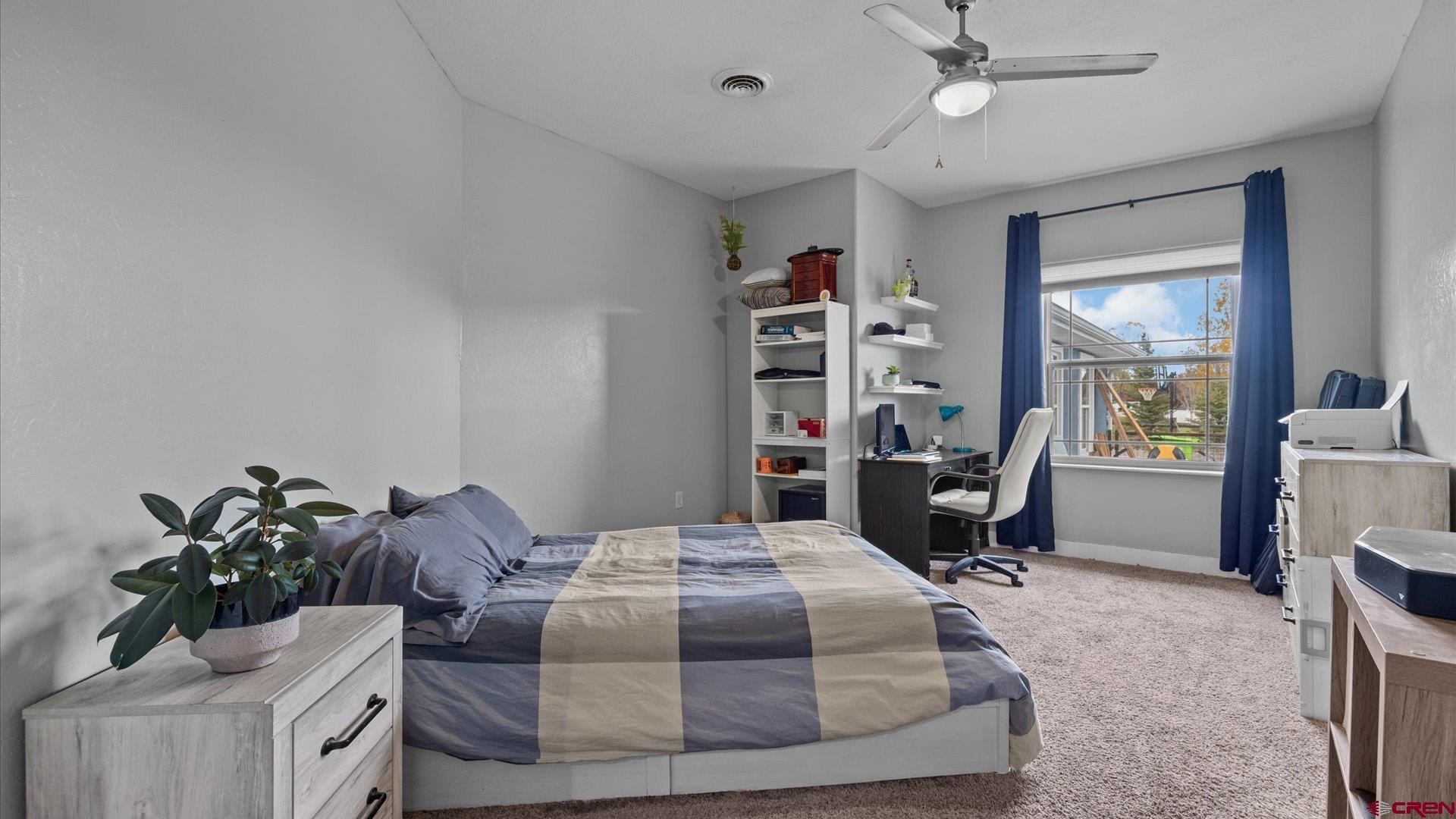 20866 Trophy Road Montrose, CO 81403 - Photo 13 of 29 a bedroom with a bed a chandelier and a bookshelf