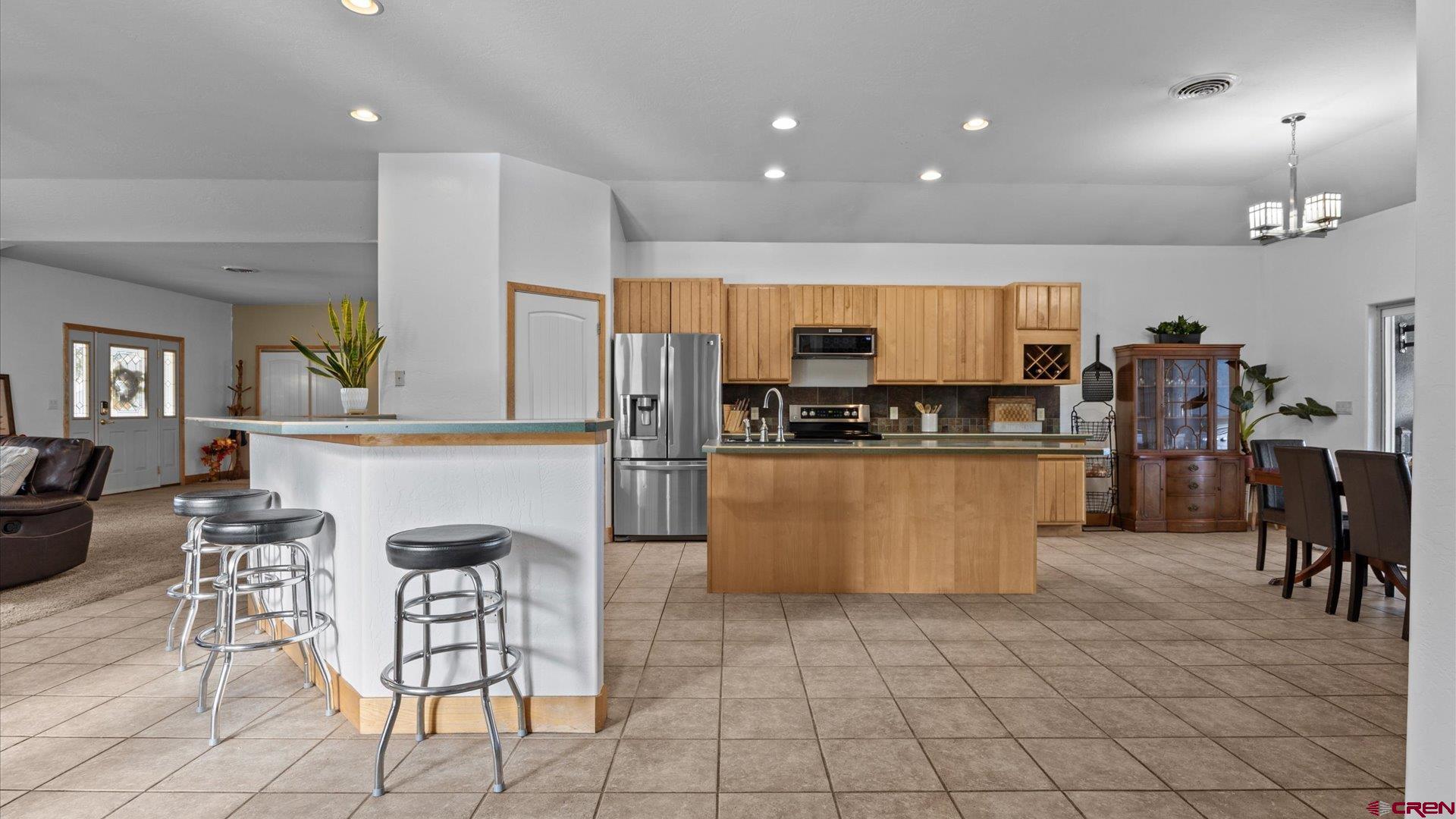 20866 Trophy Road Montrose, CO 81403 - Photo 3 of 29 a kitchen with stainless steel appliances a refrigerator a stove a sink a dining table and chairs with wooden floor