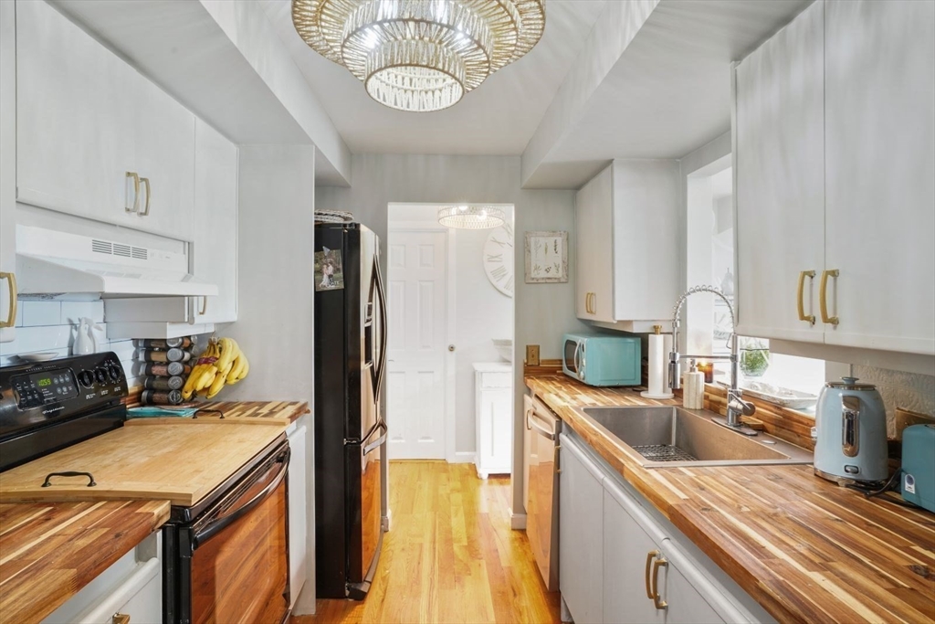 1 Commodore Court, Unit 104 Hull, MA 02045 - Photo 11 of 35 a kitchen with stainless steel appliances granite countertop a sink stove and refrigerator