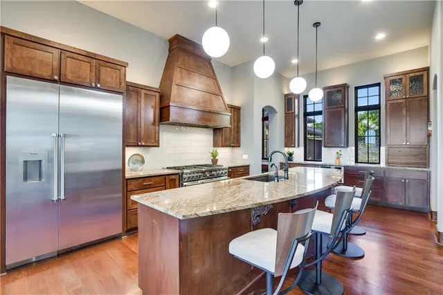 a kitchen with a table chairs refrigerator and wooden floor