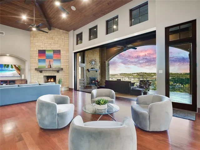 a living room with fireplace furniture and a large window