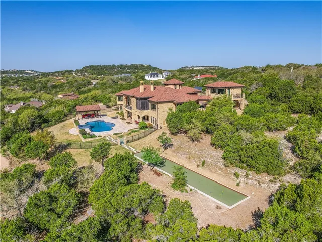 an aerial view of residential houses with outdoor space and trees