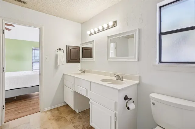 a bathroom with a sink toilet double vanity and shower