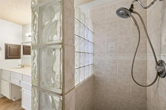 a bathroom with a granite countertop shower and mirror