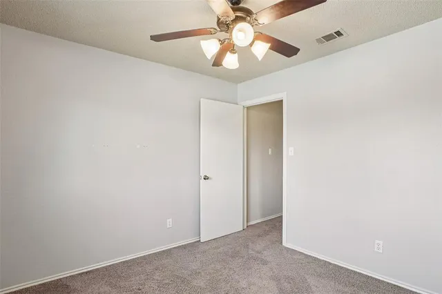 an empty room with a fan and a fan
