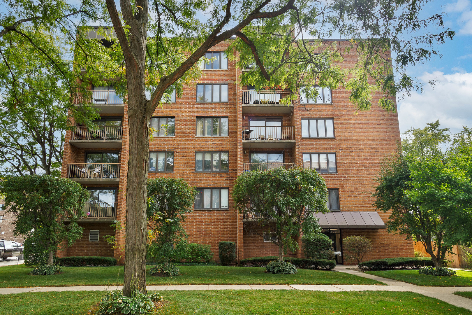1389 Perry Street, Unit 303 Des Plaines, IL 60016 - Photo 1 of 25 a front view of a building with trees