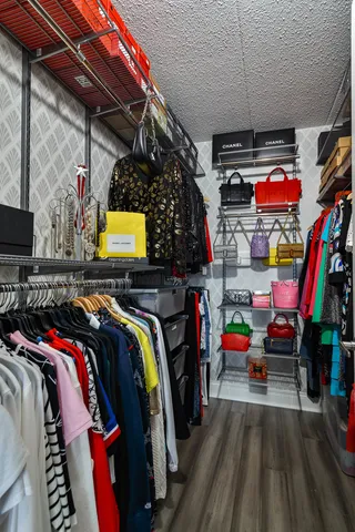 a view of walk in closet with clothes and shoes
