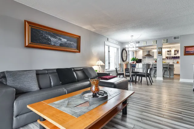 a living room with furniture a dining table and kitchen view