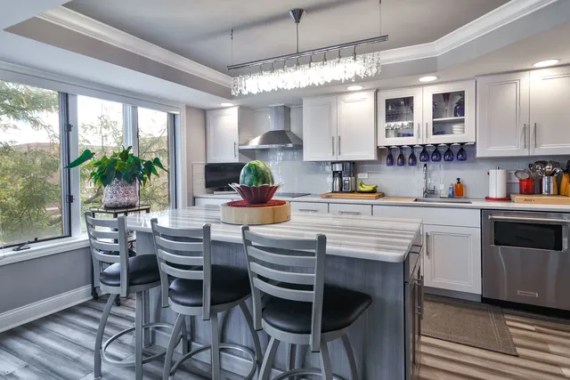 a kitchen with a white cabinets and chairs