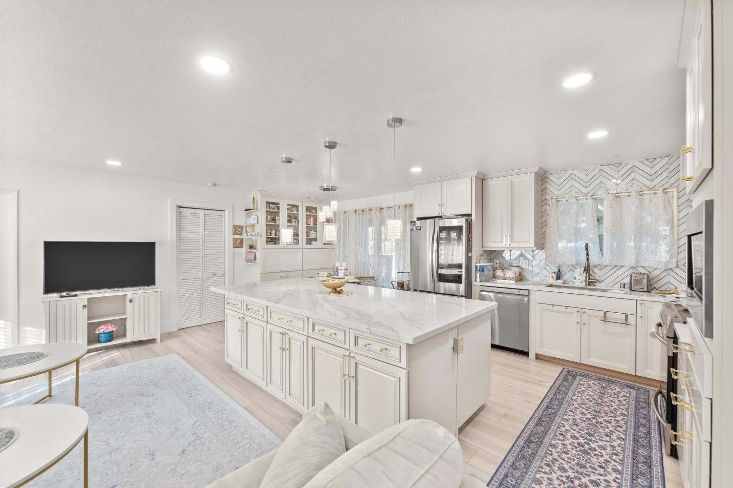 8850 Bader Road Elk Grove, CA 95624 - Photo 14 of 43 a large white kitchen with stainless steel appliances kitchen island granite countertop a large counter top and sink