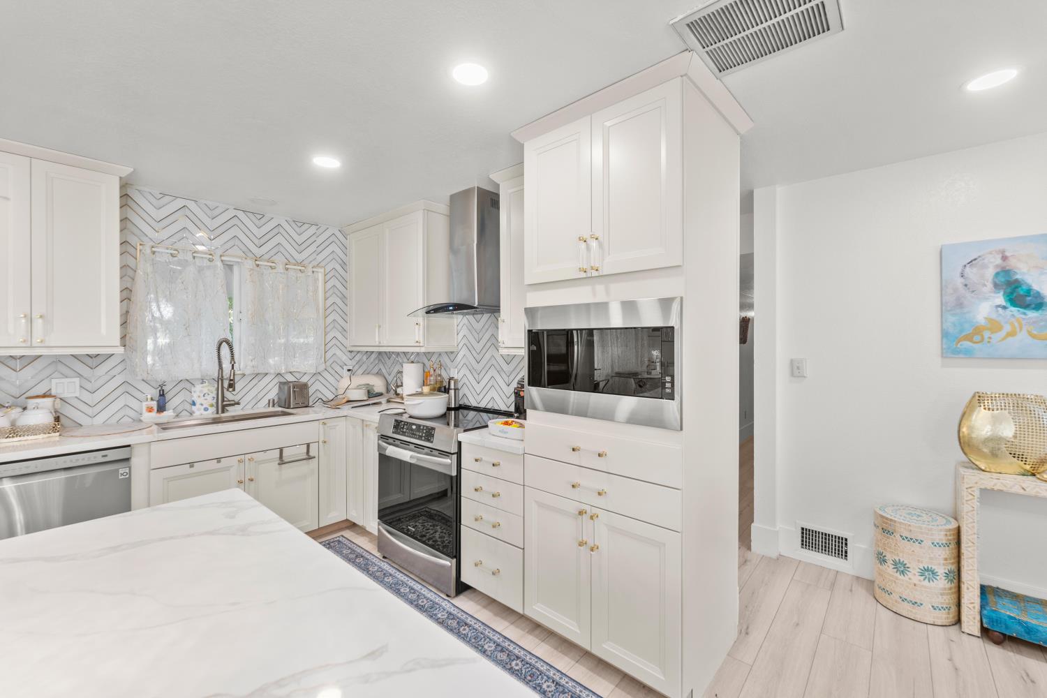 8850 Bader Road Elk Grove, CA 95624 - Photo 15 of 43 a kitchen with white cabinets and appliances