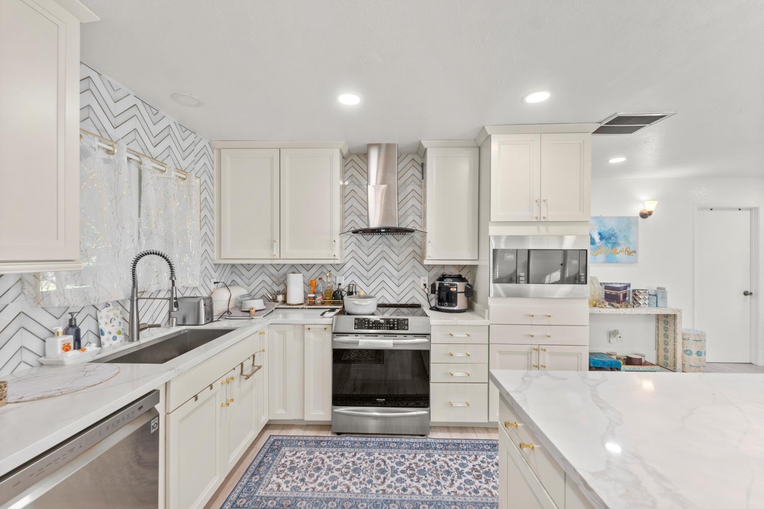 8850 Bader Road Elk Grove, CA 95624 - Photo 17 of 43 a kitchen with a sink stove and cabinets