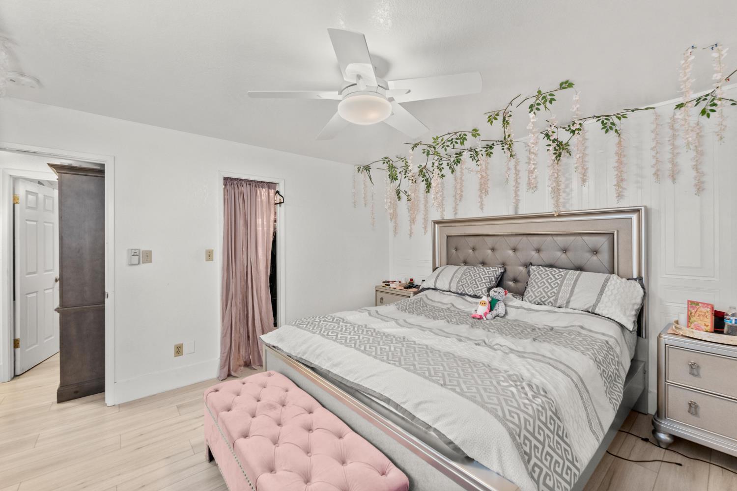 8850 Bader Road Elk Grove, CA 95624 - Photo 24 of 43 a bedroom with a large bed and a chandelier