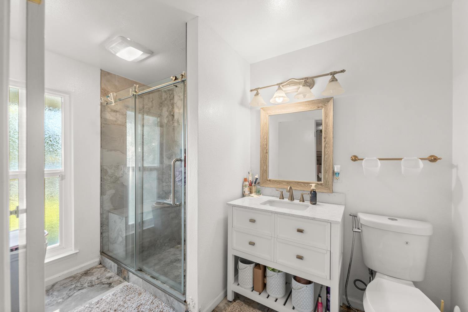 8850 Bader Road Elk Grove, CA 95624 - Photo 26 of 43 a bathroom with a sink a toilet a mirror and shower