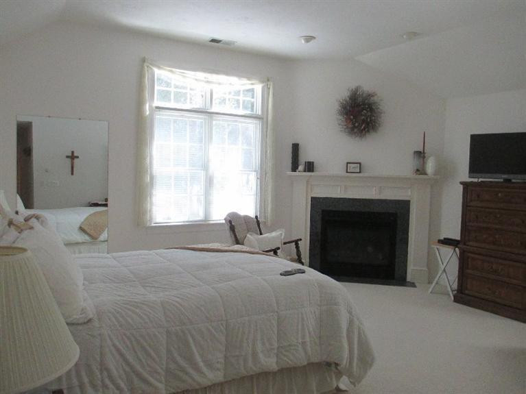 27 Forest Hills Road Cotuit, MA 02635 - Photo 13 of 28 a bedroom with a bed and a fireplace