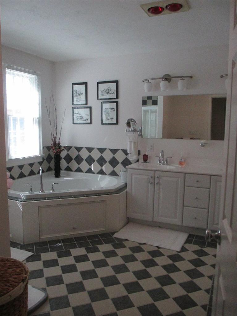 27 Forest Hills Road Cotuit, MA 02635 - Photo 18 of 28 a room with a black white checkered floor with a white kitchen