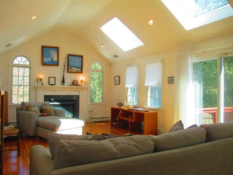 27 Forest Hills Road Cotuit, MA 02635 - Photo 3 of 28 a living room with furniture fireplace and a large window