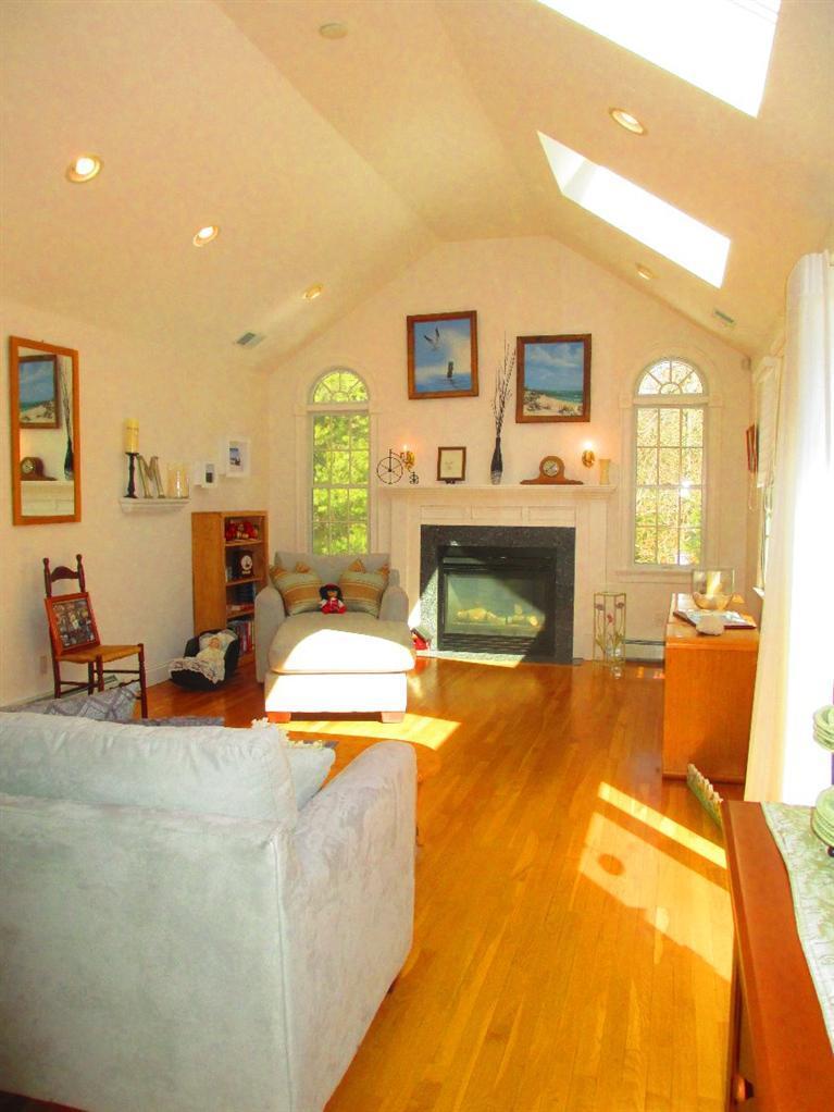 27 Forest Hills Road Cotuit, MA 02635 - Photo 4 of 28 a living room with furniture and a fireplace