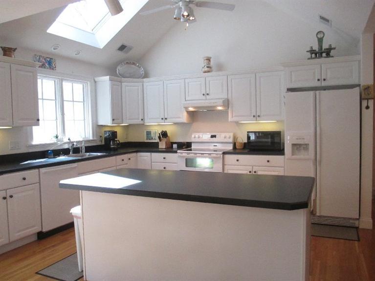 27 Forest Hills Road Cotuit, MA 02635 - Photo 5 of 28 a kitchen with granite countertop a sink a center island stainless steel appliances and cabinets