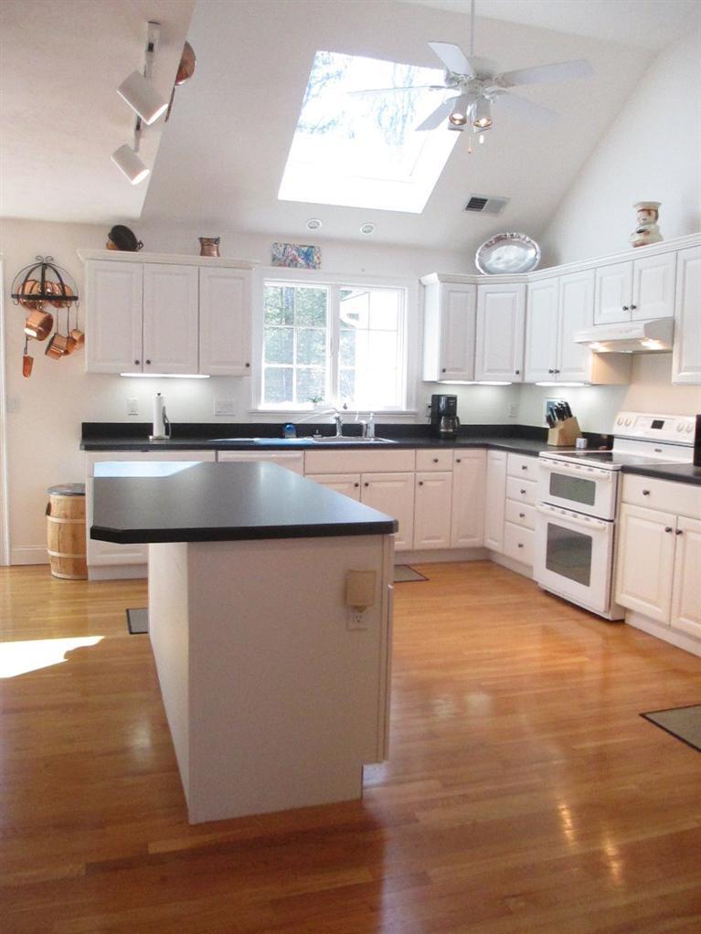 27 Forest Hills Road Cotuit, MA 02635 - Photo 7 of 28 a kitchen with stainless steel appliances granite countertop a sink counter space cabinets and a window