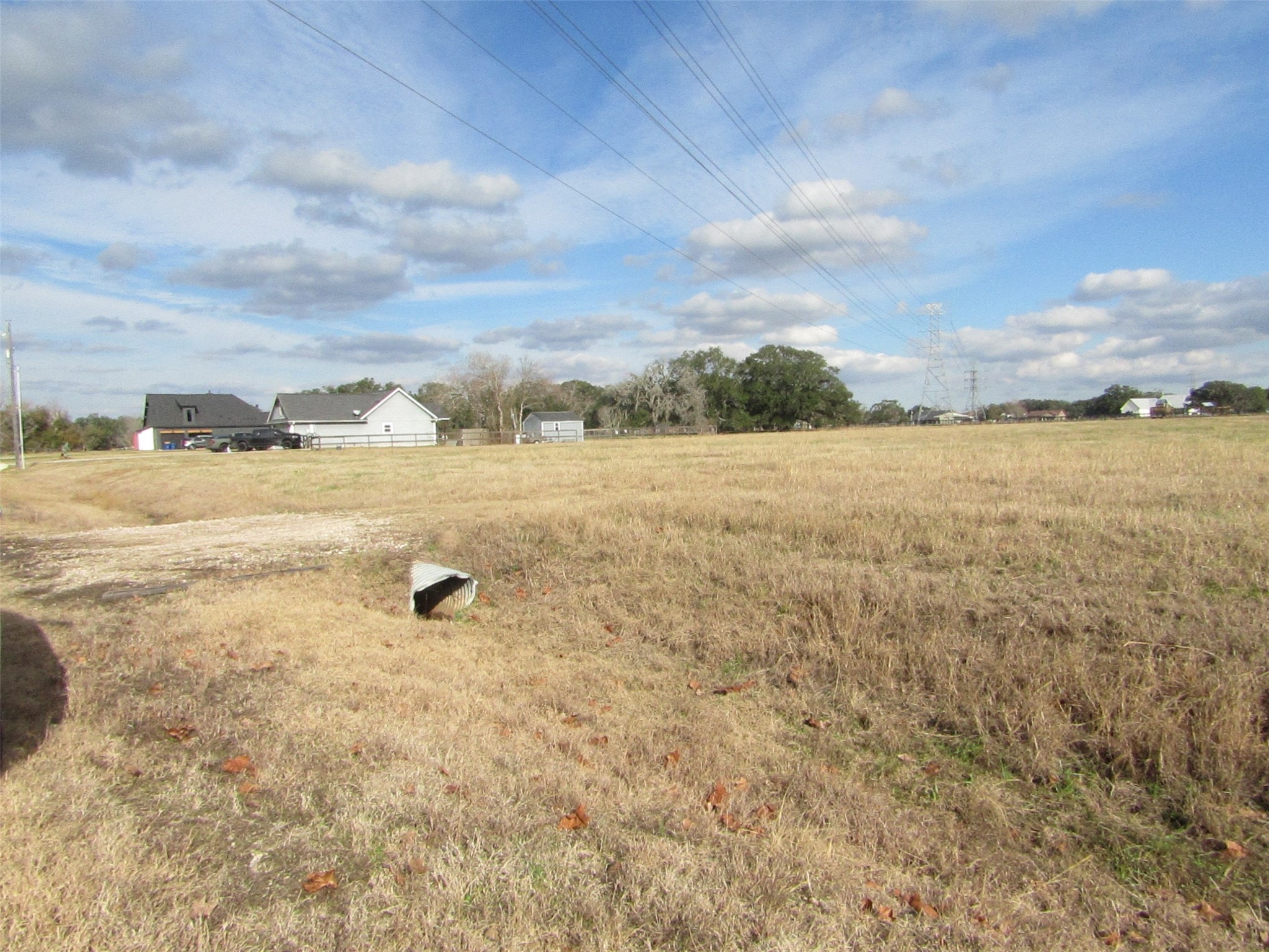 707 Winchester Trail Angleton, TX 77515 - Photo 6 of 8 Expansive 3.33-acre lot with open grassy fields, nearby houses—ideal for building your dream home in a serene neighborhood. You can also divide the acres into 3= 1.11 acre lots.