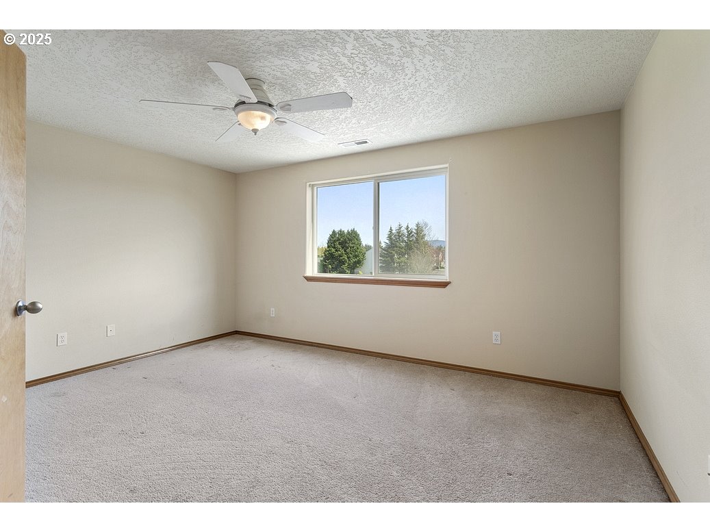 3021 Southeast Pheasant Avenue Gresham, OR 97080 - Photo 12 of 26 an empty room with windows and ceiling fan