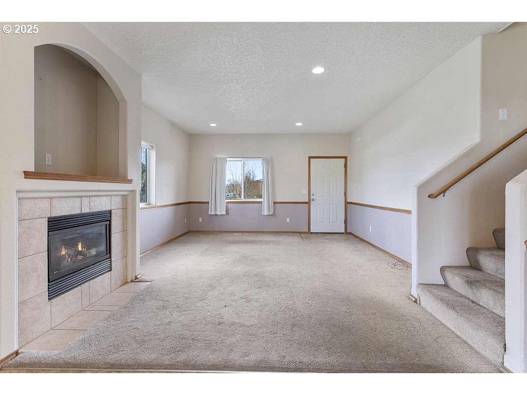 3021 Southeast Pheasant Avenue Gresham, OR 97080 - Photo 6 of 26 a view of empty room with fireplace and wooden floor