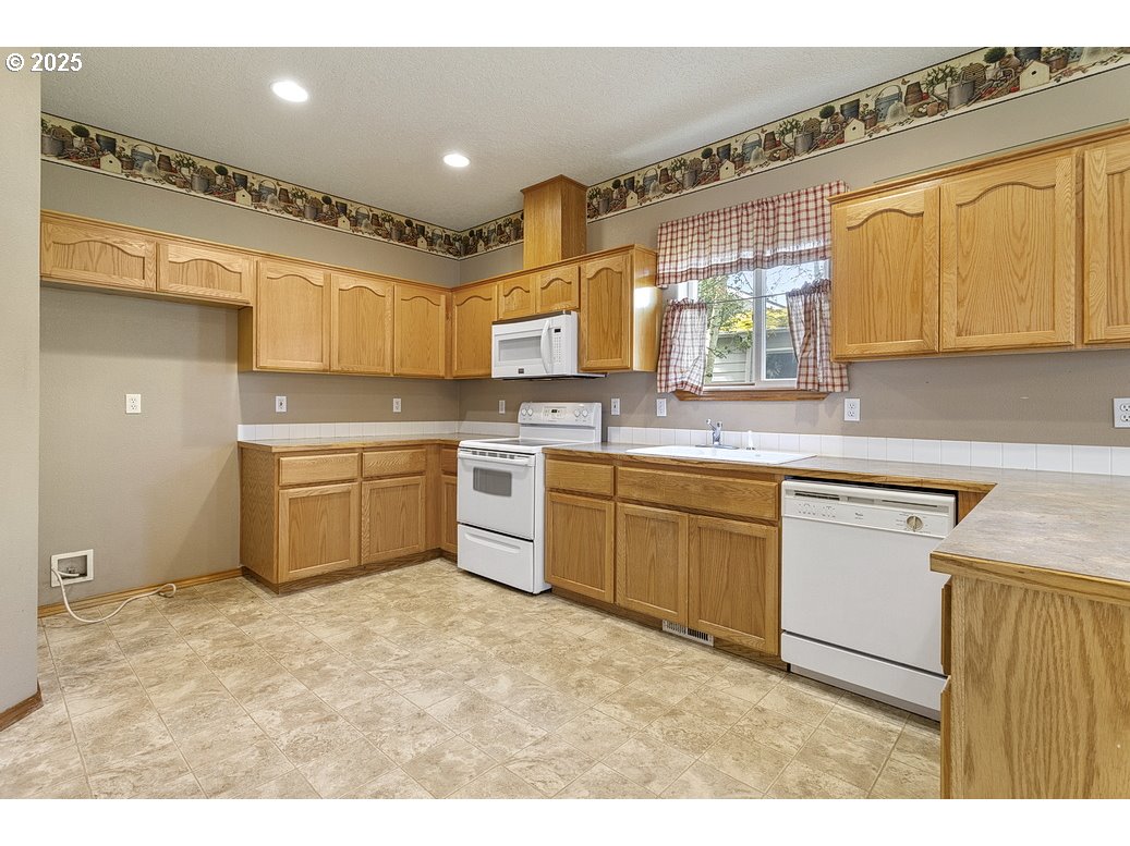 3021 Southeast Pheasant Avenue Gresham, OR 97080 - Photo 9 of 26 a kitchen with a sink window and cabinets