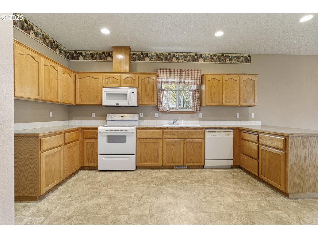 3021 Southeast Pheasant Avenue Gresham, OR 97080 - Photo 10 of 26 a kitchen with a stove top oven sink and cabinets