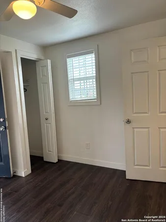 an empty room with wooden floor and window