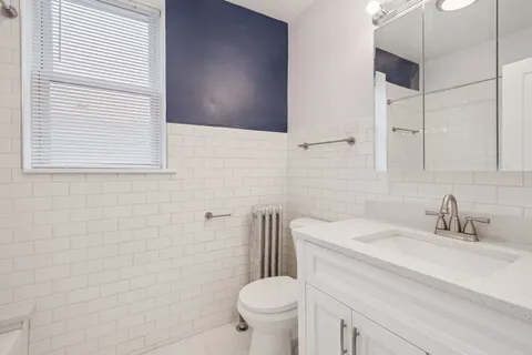 a bathroom with a sink a toilet and a mirror