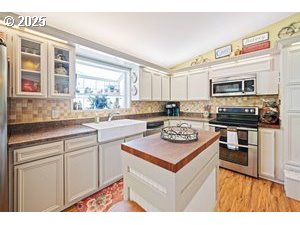 845 Northwest 3rd Street Gresham, OR 97030 - Photo 12 of 32 a kitchen with a sink stove and cabinets