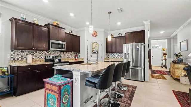 a kitchen with stainless steel appliances kitchen island granite countertop a sink stove and refrigerator