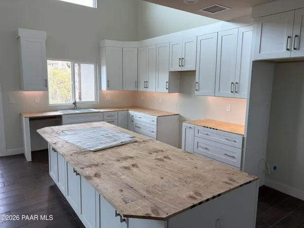 a kitchen with kitchen island sink refrigerator and cabinets