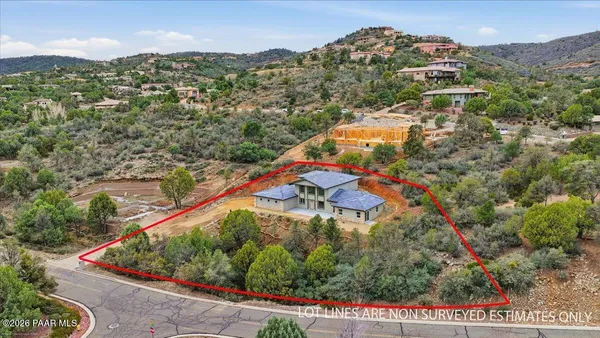 an aerial view of residential houses with outdoor space and trees
