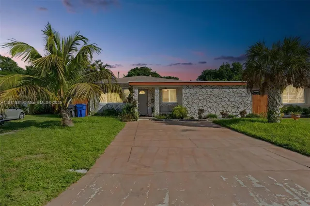 a front view of house with small garden and palm tree