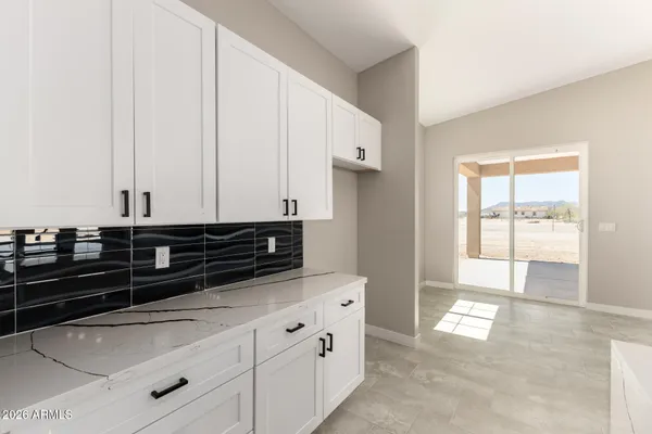 a kitchen with granite countertop white cabinets and white appliances