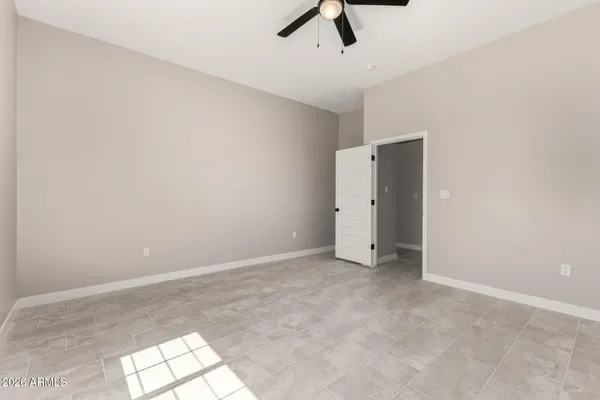 an empty room with ceiling fan and window