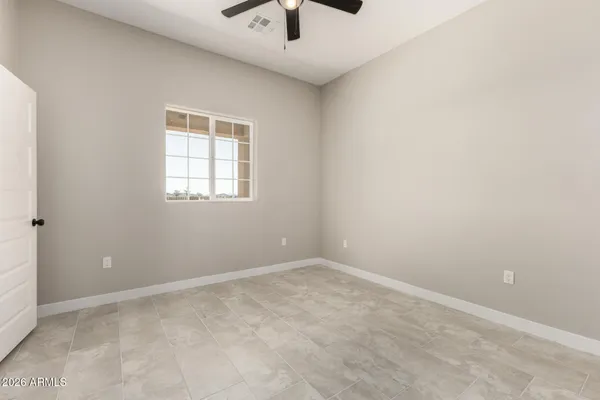 an empty room with a window and a ceiling fan