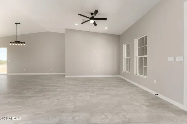 an empty room with a ceiling fan and a window