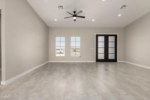 an empty room with windows and ceiling fan