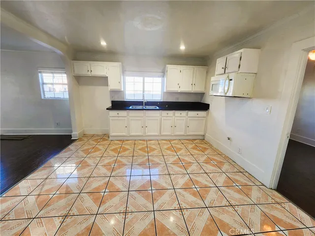 a large kitchen with a black white checkered floor