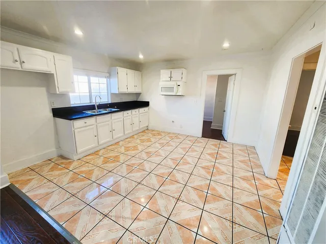 a large kitchen with a sink and a stove top oven