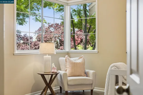 a view of a patio with table and chairs potted plants and tree with wooden fence