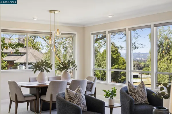 a large white kitchen with stainless steel appliances a stove a sink dishwasher and white cabinets with wooden floor