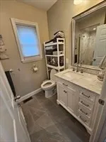 a bathroom with a granite countertop sink mirror and toilet